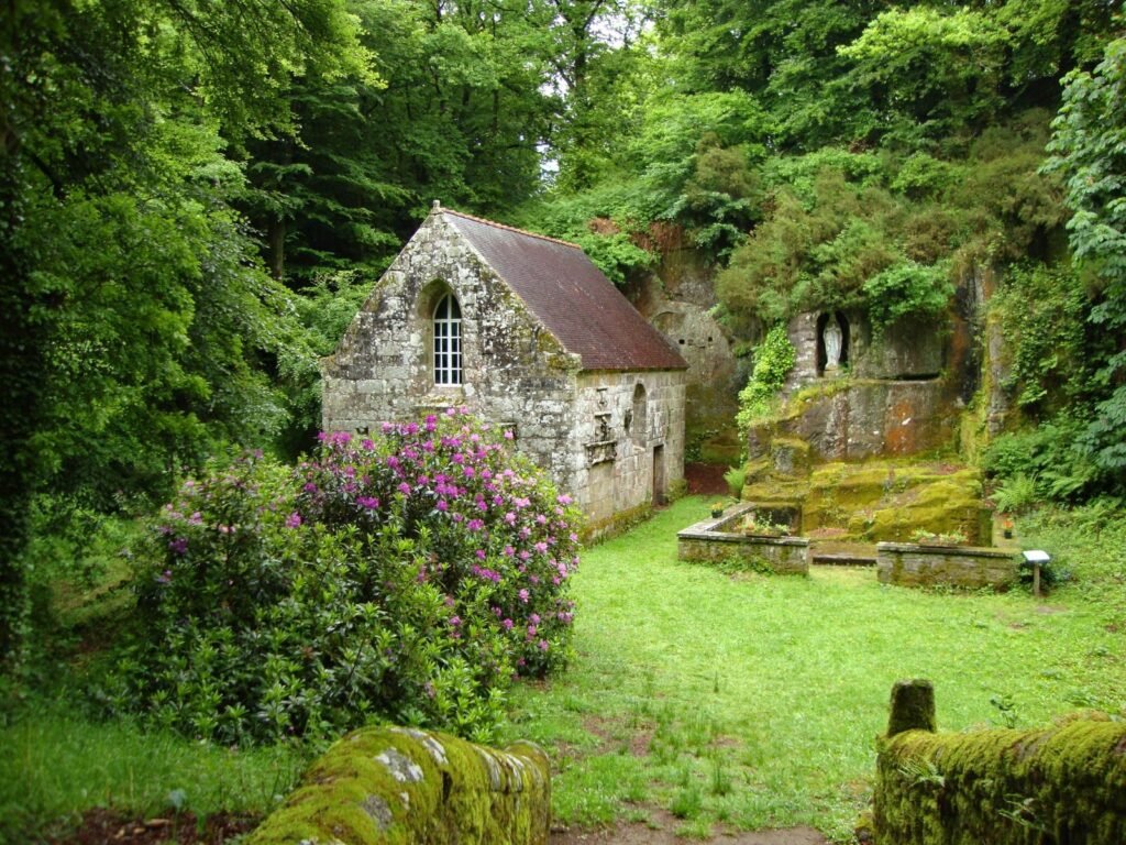 A serene ancient stone building amidst a vibrant forest landscape in summer.